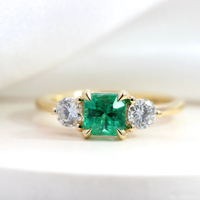 Emerald trilogy engagement ring with diamond yellow gold